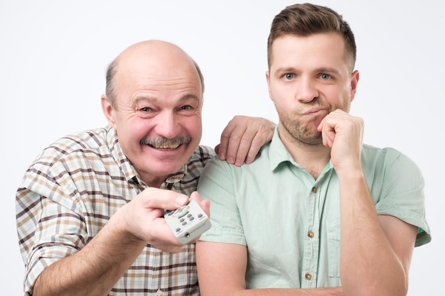 Père et fils choisissent un film à regarder à la télévision