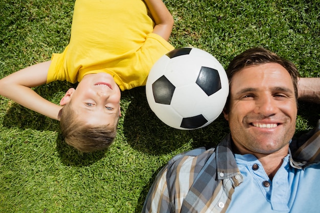 Père et fils couché sur l'herbe dans le parc