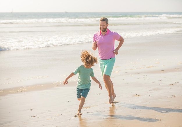 Père et fils courant sur la plage du matin. week-end de voyage en famille et vacances.