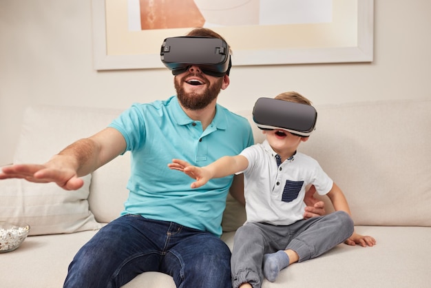 Père et fils dans des lunettes vr faisant l'expérience du cyberespace