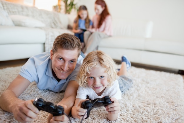 Père et fils dans le salon en jouant à des jeux vidéo