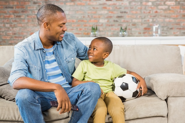 Père et fils devant la télé ensemble sur le canapé