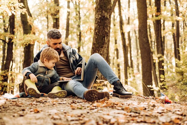 Père et fils d'enfant dans le parc d'automne s'amusant et riant