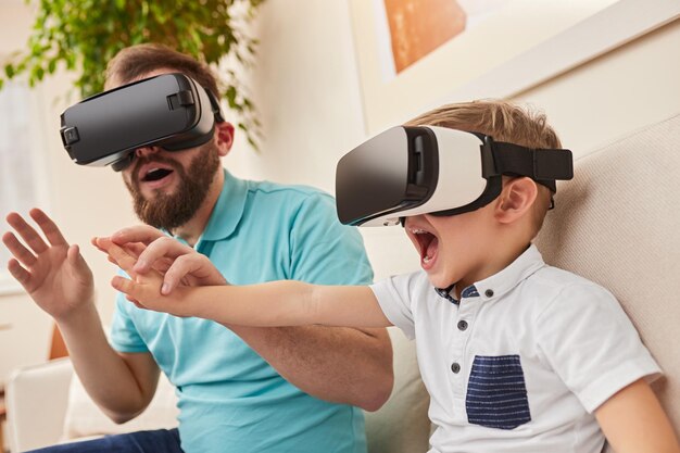 Père et fils étonnés explorant la réalité virtuelle