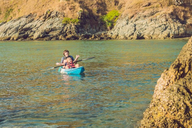 Père et fils faisant du kayak dans l'océan tropical.