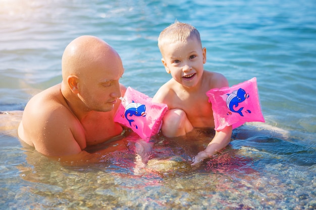 père et fils heureux nageant dans la mer