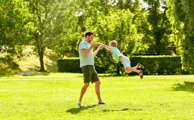 père et fils heureux s'amusant au parc d'été