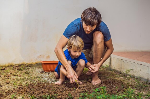 Père et fils jardinant dans le jardin près de la maison