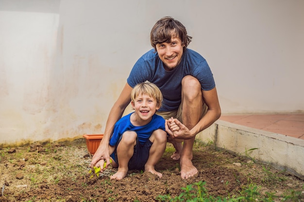 Père et fils jardinant dans le jardin près de la maison