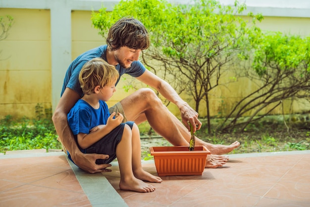 Père et fils jardinant dans le jardin près de la maison