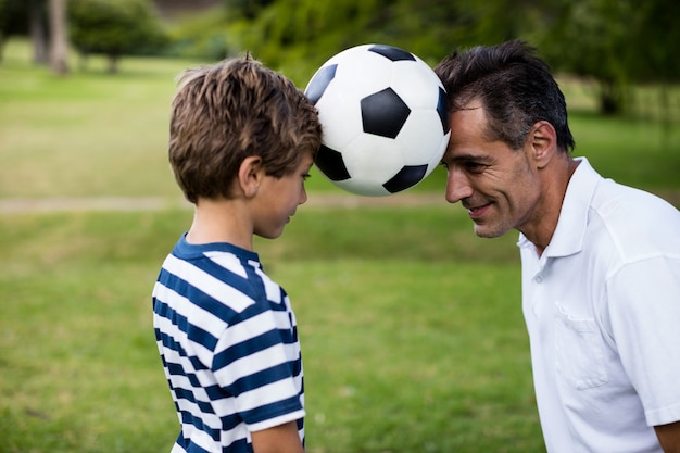 Père et fils jouant au football