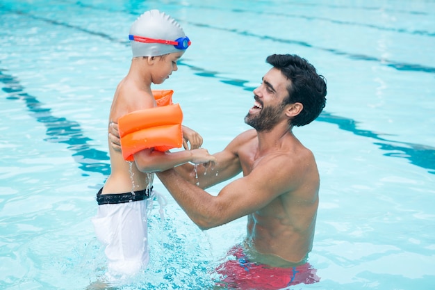 Père et fils jouant dans la piscine