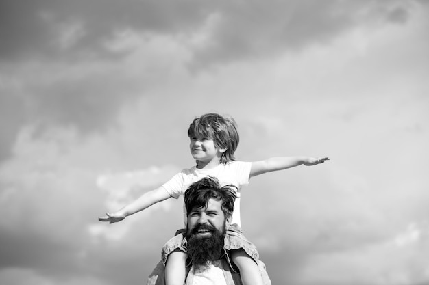 Père et fils jouant ensemble, l'enfant est assis sur les épaules de son père en famille