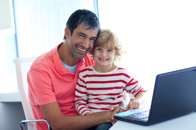 Père et fils jouant avec un ordinateur portable
