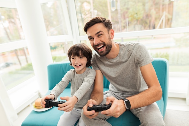 Père et fils jouent ensemble dans des jeux informatiques