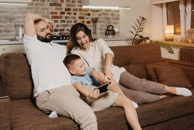 Un père, un fils et une maman sur le canapé