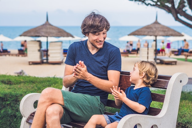 Père et fils mangent des patates douces frites dans le parc.