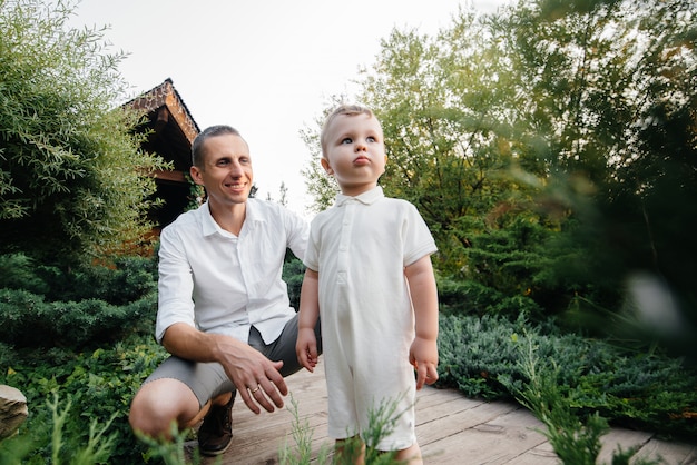 Photo père et fils marchant dans le parc au coucher du soleil. bonheur. amour.