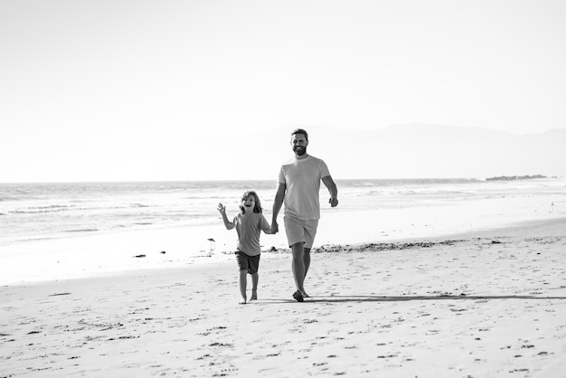 Père et fils marchant sur la mer Papa et enfant se tenant la main et marchant ensemble Concept de famille heureuse