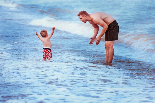 Père et fils à la mer au coucher du soleil