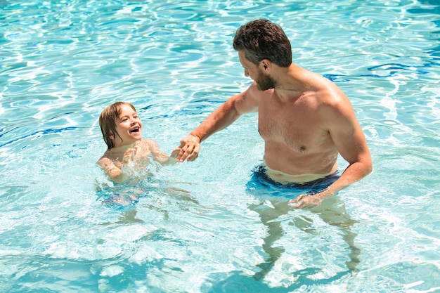 Père et fils nageant dans la piscine loisirs d'été en famille papa et fils en cours de natation vacances d'été ...