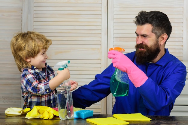 Père et fils nettoyant l'enfant peu d'aide