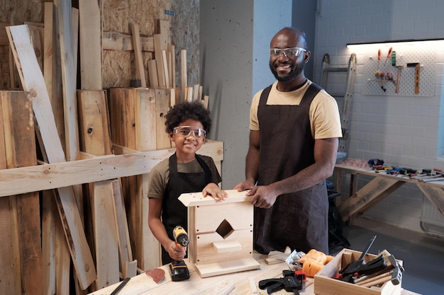 Père et fils noirs construisant un nichoir