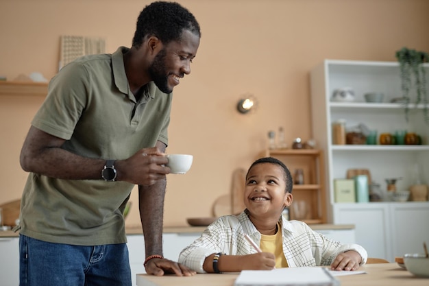 Un père et un fils noirs heureux dans la cuisine.