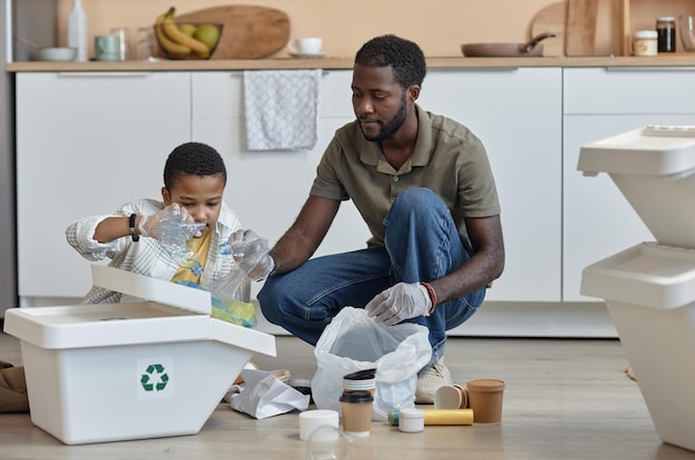 Père et fils noirs triant le recyclage