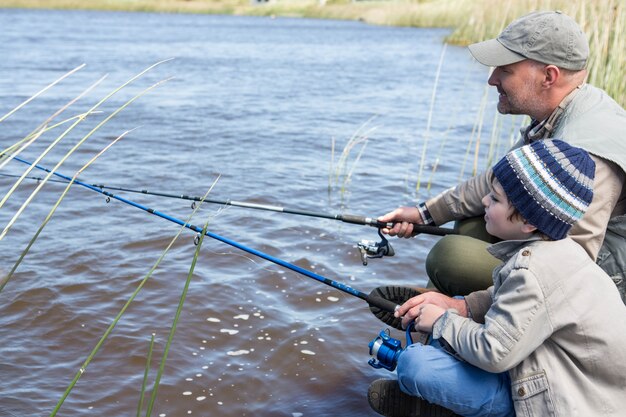 Père et fils pêchant au bord d&#39;un lac