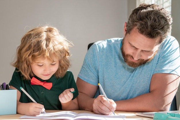 Père et fils peignant à la maison, la famille aide le garçon à faire ses devoirs avec l'enseignant