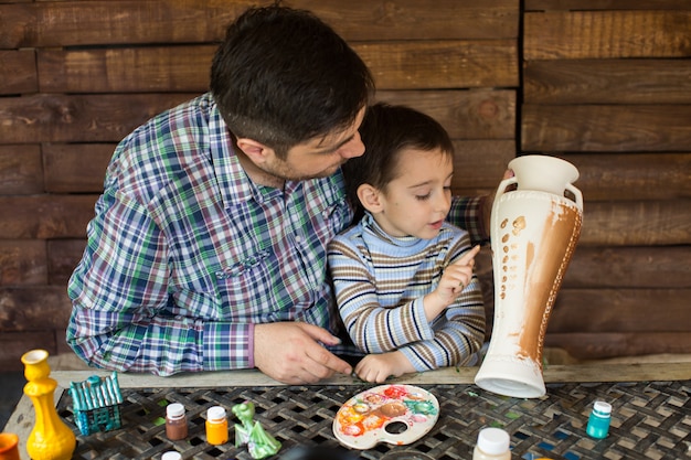 Père et fils peignent un vase