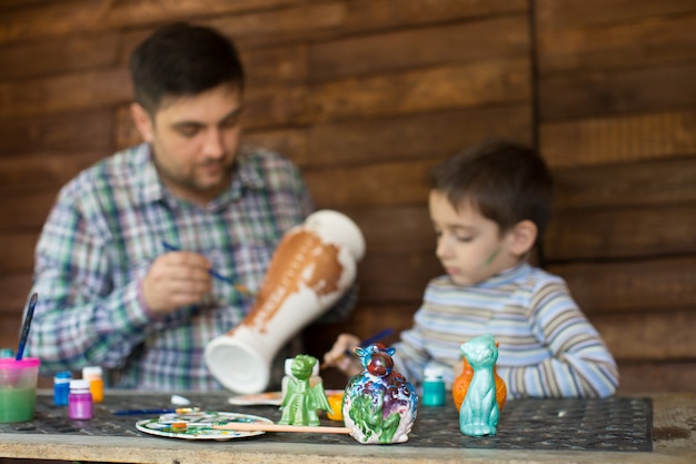 Photo père et fils peignent un vase