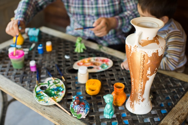 Photo père et fils peignent un vase