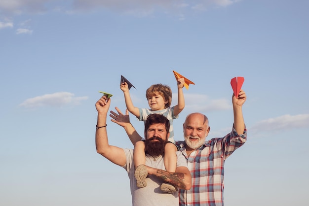Père et fils. Père et fils jouant sur le ciel bleu d'été. Notion de fête des pères. Multi génération.