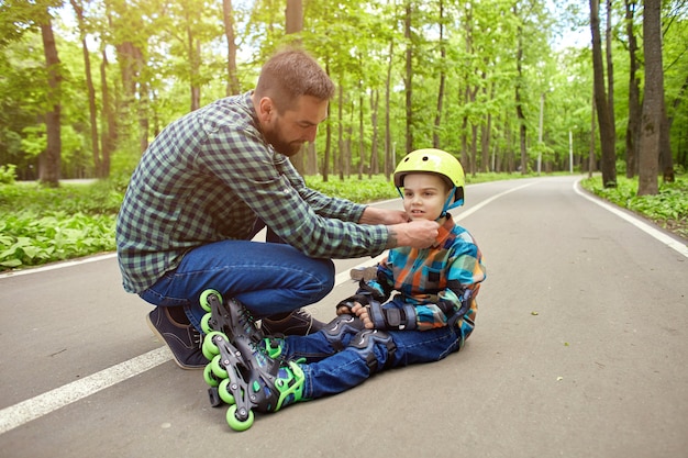 Père et fils en plein air, se préparant au patinage à roulettes