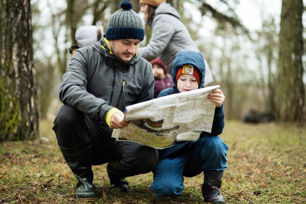 Père avec fils regardant la carte dans la forêt