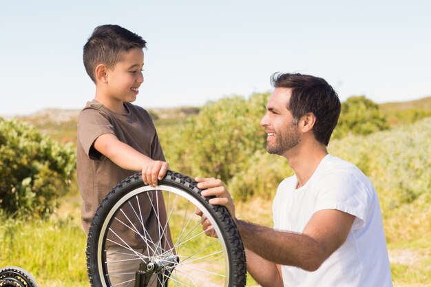 Père et fils réparent vélo ensemble