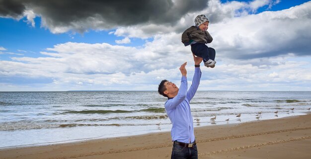 Père et fils s&#39;amusant plage de sable blanc