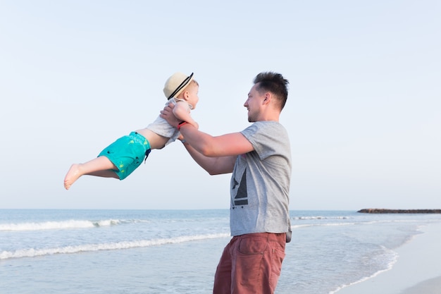 Père et fils s'amusant sur une plage