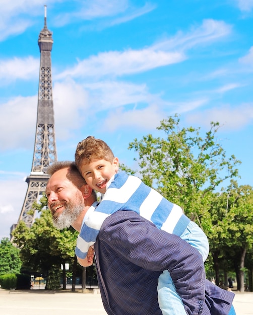 Père et fils s'amusent contre la tour Eiffel, Paris.