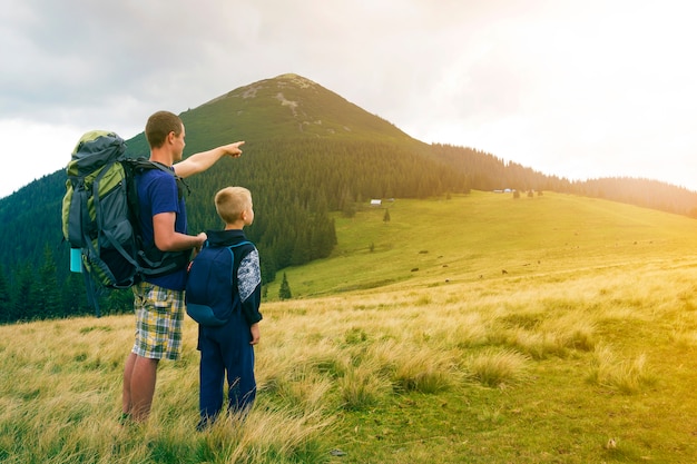 Père et fils avec sacs à dos, randonnées ensemble à la montagne