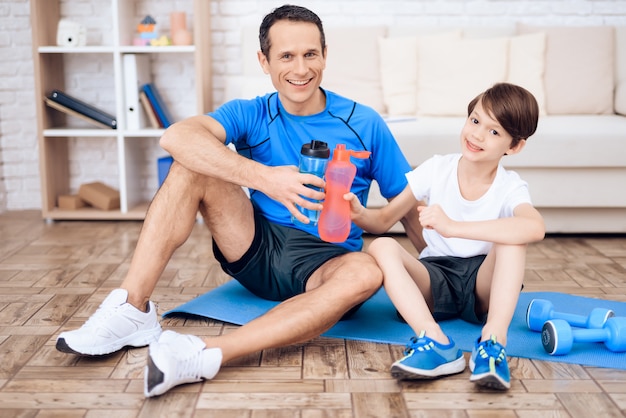 Père et fils se reposent après l&#39;exercice.