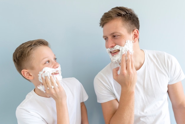 Père et fils se ressemblant avec de la crème à raser