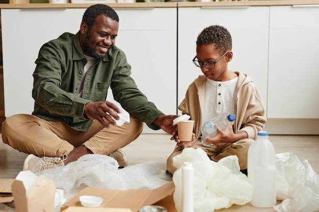 Père et fils triant du plastique à la maison