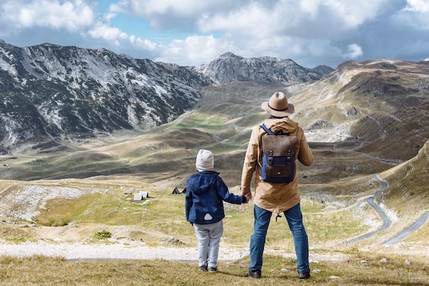 Père et fils voyagent ensemble dans les montagnes d'automne Durmitor Monténégro