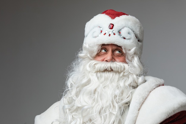 Père Frost pensif en chapeau avec barbe blanche.