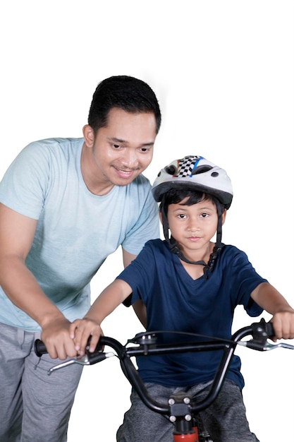 Un père guide son fils à vélo sur le studio.