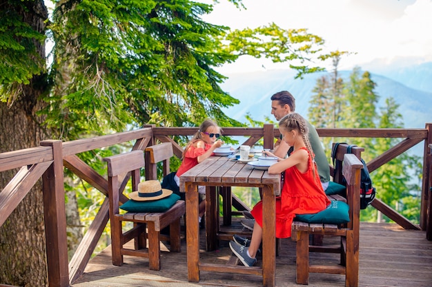 Père heureux avec des enfants dans les montagnes en arrière-plan de brouillard