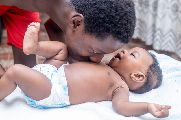 Photo un père heureux passe du temps avec son bébé sur le canapé de son salon.